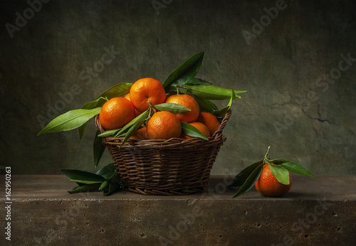 Still life with tangerines in a basket on the table