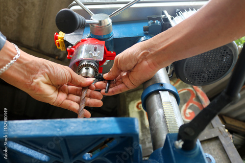 Drill presses machine with machinist. 