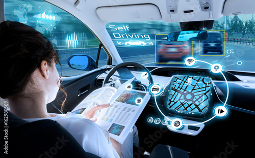 young woman reading a book in a autonomous car. driverless car. self driving vehicle. heads up display. automotive technology.