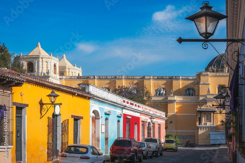 Sunny afternoon on the main street in Antigua Guatemala with colorful heritage houses.