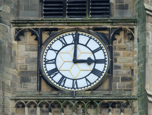 church clock white face with roman numerals at three o clock in the church in huddersfield