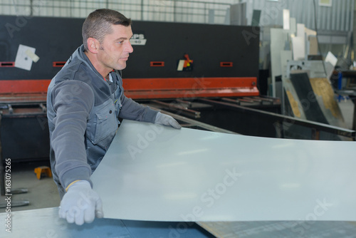 man working at a factory manufacturing tempered clear float glass