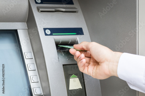 man hand insert credit card to atm