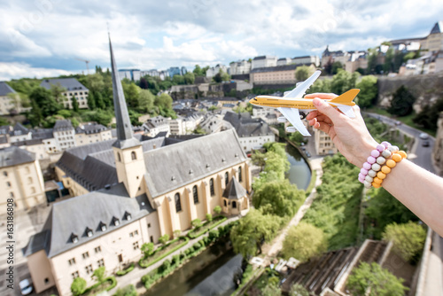 Holding a toy airplane on the old town background in Luxembourg city