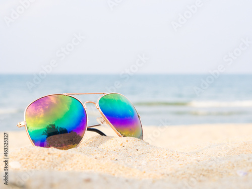 sunglasses on the beach with sea and sailboat backround, Concept of summer traveling