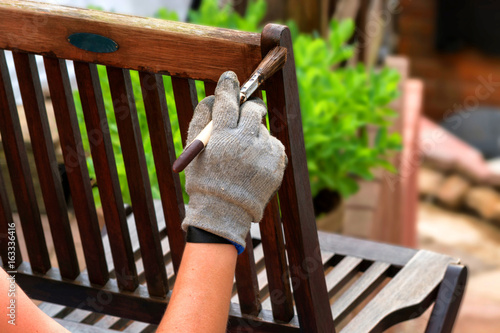 Women hand with brush strokes wooden furniture