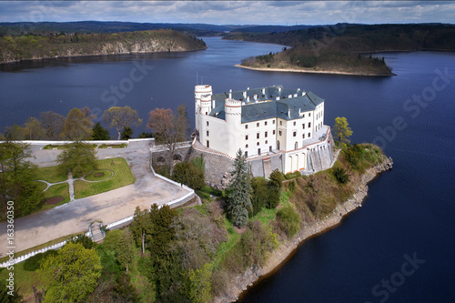 Aerial view on czech romantic, gothic chateâu Orlik, situated on rock outcrop above Orlik reservoir in beautiful spring nature. Romantic,royal Schwarzenberg castle above water level. Czech landscape.