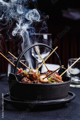 Meat on skewers smoks in a brazier