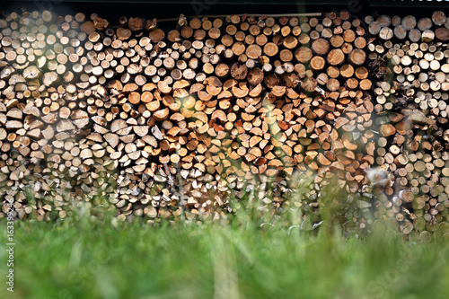 Drewno opalowe.Drewno opałowe poukładane w komórce do przechowywania drewna.