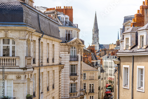 Street view on the beautiful residential buildings andchurch tower in Nantes city during the sunny day in France