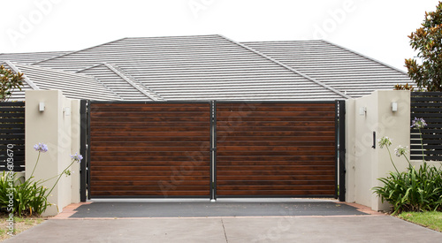 Wooden driveway entrance gates set in brick fence