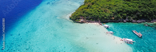 Aerial view of sandy beach with tourists swimming in beautiful clear sea water of the Sumilon island beach landing near Oslob, Cebu, Philippines. - Boost up color Processing. Panoramic banner.