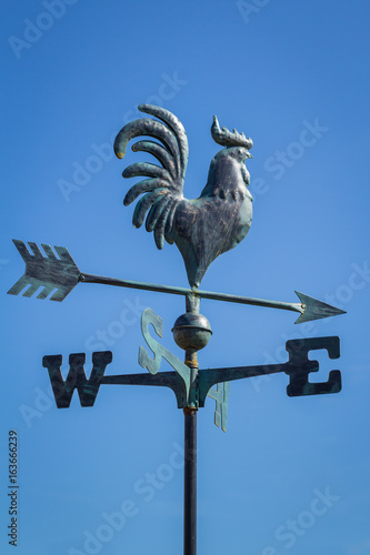 Weather vane showing direction of wind against clear blue sky, vertical