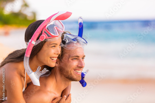 Happy travel beach snorkeling couple enjoying summer holidays vacation fun. Multiracial people together in love with diving masks, sports leisure activity for vacations.