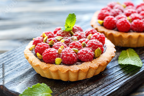 Mini tarts with chocolate, raspberry and pistachio.