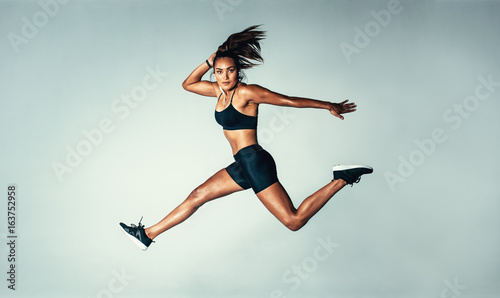 Female model in sports wear jumping in air