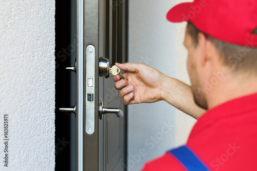 door lock service - locksmith working in red uniform