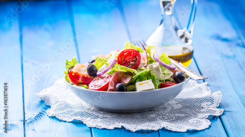 Salad. Fresh summer lettuce salad.Healthy mediterranean salad olives tomatoes parmesan cheese and prosciutto