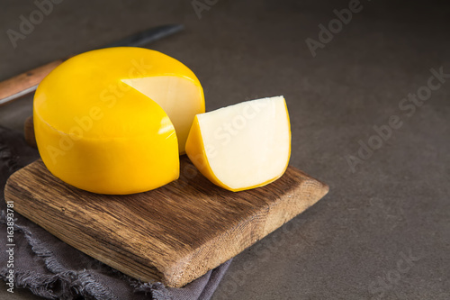 Round gouda cheese. Dark background.