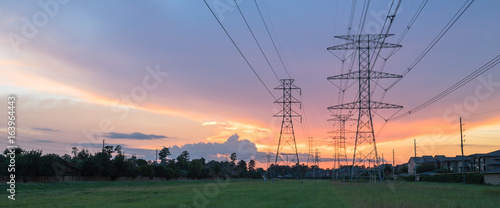 Group silhouette of transmission towers (power tower, electricity pylon, steel lattice tower) at twilight in US. Texture high voltage pillar, overhead power line, industrial background. Panorama style