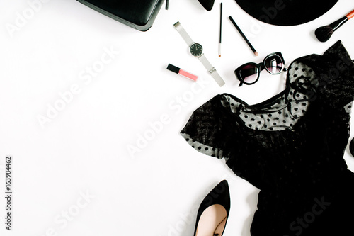 Trendy fashion black styled woman clothes and accessories collection on white background. Flat lay, top view. Dress, high heels, sunglasses, purse, watches.