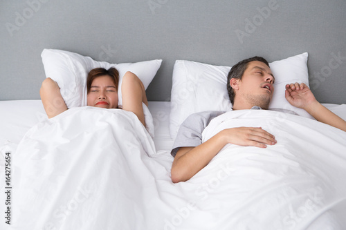 Angry Asian woman annoyed with husbands snoring