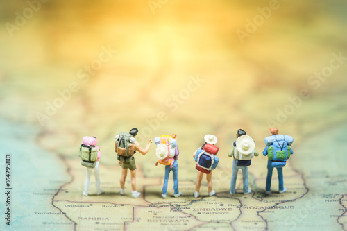 Selective focus. Miniature people : small traveler figures with backpack standing on South Africa Map / Geography of South Africa, exploring on earth background concept.