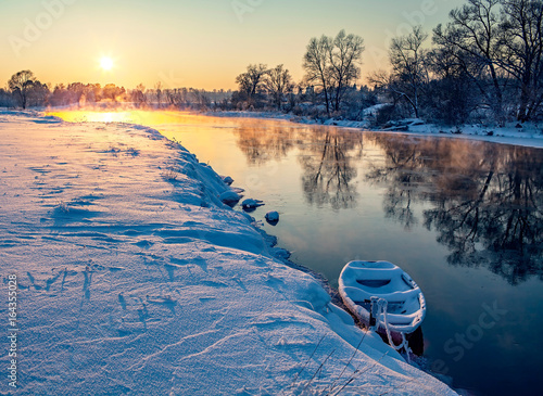 Зимний закат на реке с лодкой. Река Руза у деревни Ракитино