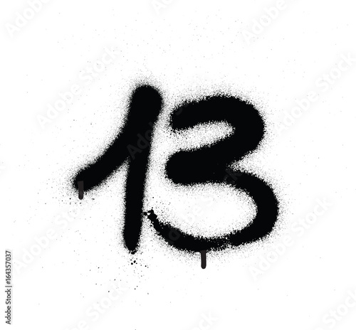 graffiti sprayed number 13 thirteen in black over white