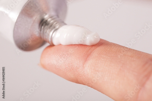 Close up image of hands with cream tube