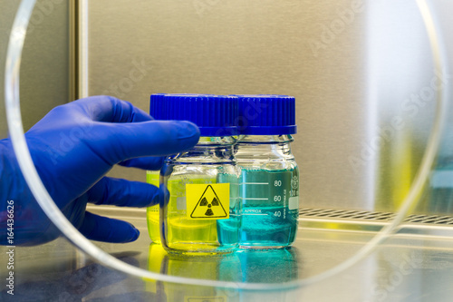 hand grasps a radioactive sample in a laboratory environment 