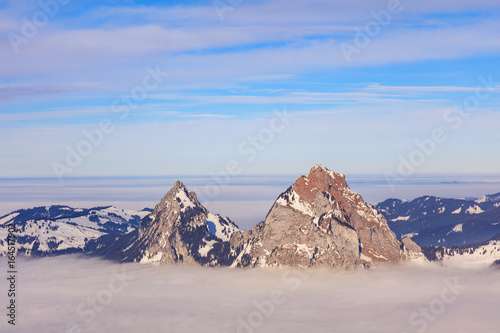 Summits of the Kleiner Mythen and Grosser Mythen mountains rising from a sea of fog