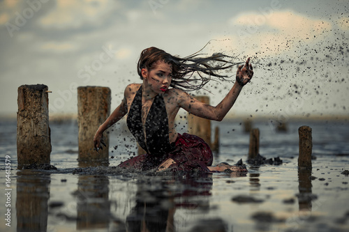 Young woman bathing in therapeutic water of mud estuary.