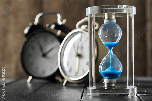 Time is passing. Blue hourglass close up
