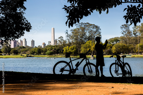 Cyclist by the lake in Ibirapuera Park, Sao Paulo, Brazil, taking photos.
