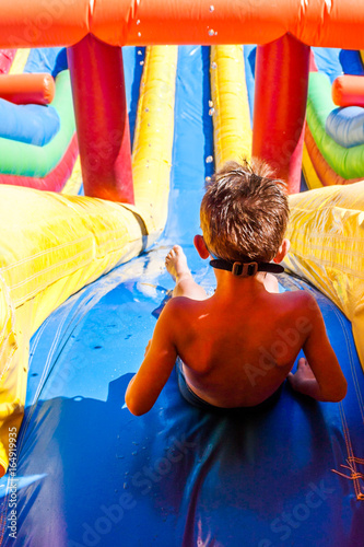 enfant en haut du grand toboggan aquatique