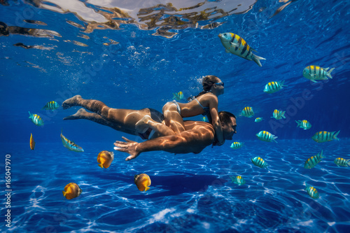 underwater image of a man and a girl