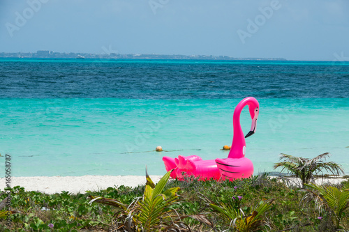 Różowy dmuchany flaming na plaży w Meksyku