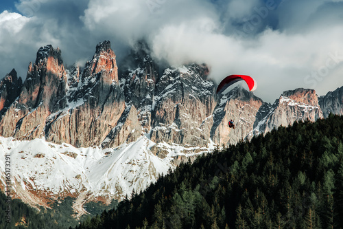 Paraglider flying near high mountains. Dolomites, Italy