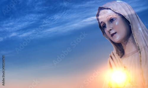Statue of the Virgin Mary against sunrise