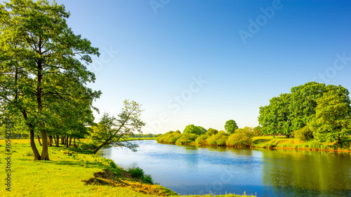 Sommerliche Landschaft mit Wiesen und Fluss