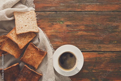 Breakfast background, toast and coffee on rustic wood, top view