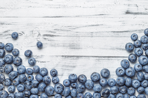 American blueberries scattered over white wooden background