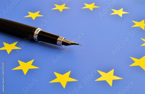 pióro na tle flagi UE