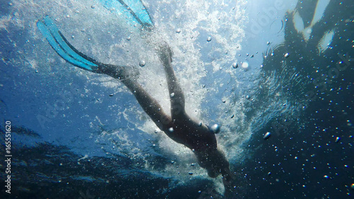 swimmer in flippers dives into the sea