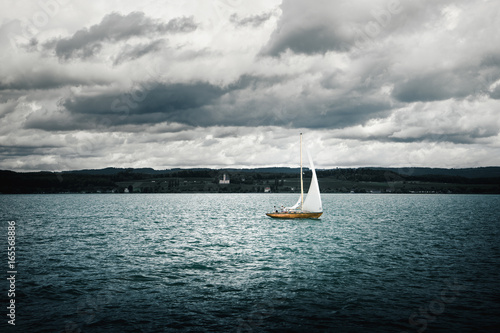 Ein Segelschiff bei rauer See mit Wind und Sturm unterhalb bewolktem himmel