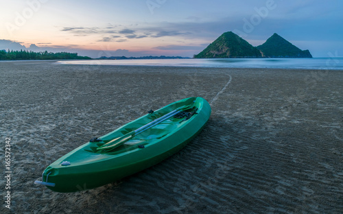 the boat on the beach with the behind is mountain.