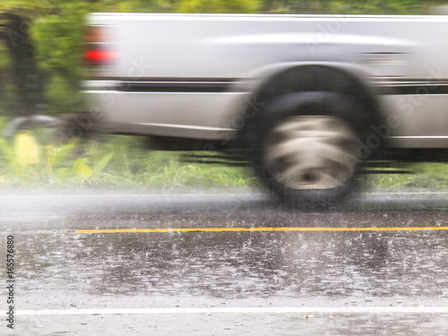 A car speeds past during torrential rain. Thailand