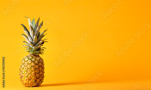 Whole pineapple on a bright yellow background
