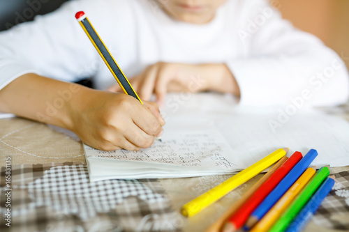 Child doing homework and writing story essay. Elementary or primary class